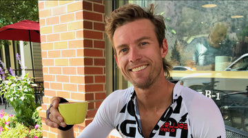 male athlete sitting outside of Color Coffee drinking his coffee in a yellow mug