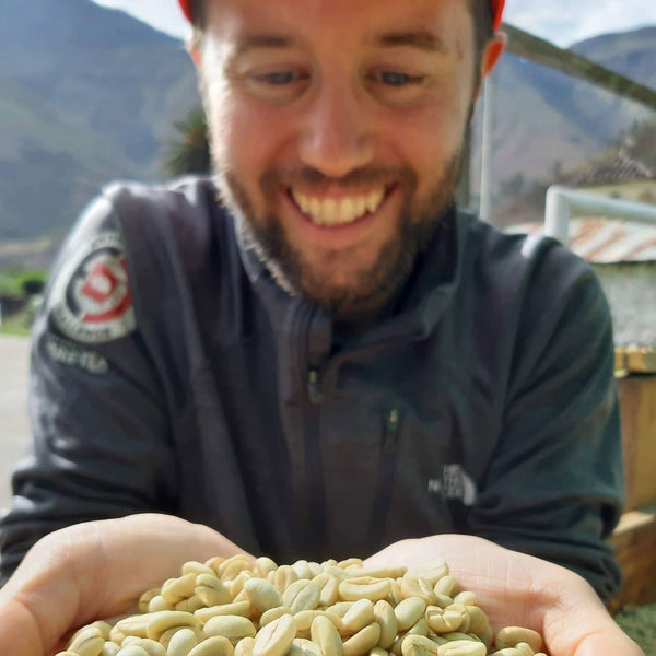 Charlie Gundlach holding his hands out with a pile of coffee beans in his hands