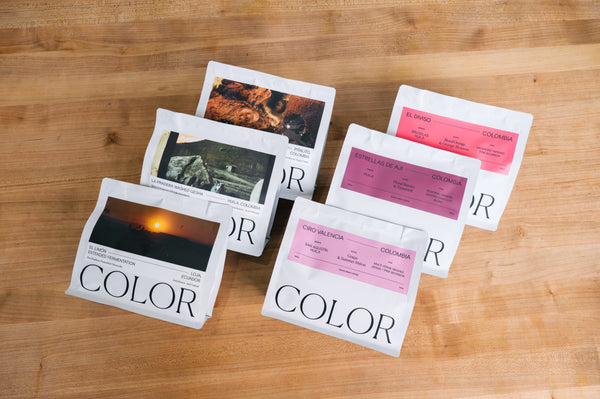 6 bags of color coffee overlapping in two rows on a wood background