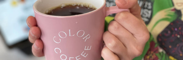 close up of a person holding a pink ceramic color coffee mug