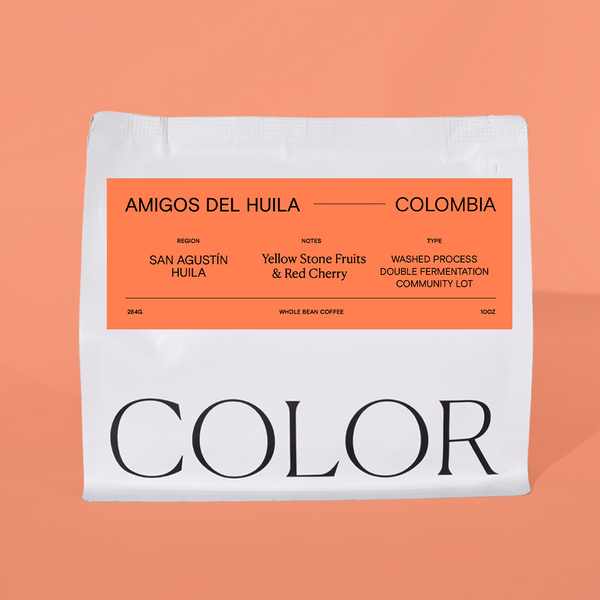 our 10oz white whole bean coffee bag with orange label and COLOR coffee logo at the bottom on an orange background.