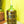 Load image into Gallery viewer, Green glass carboy with a white cork stopper on a yellow wall background

