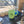 Load image into Gallery viewer, A light green ceramic mug with a black armadillo illustration sits on a black coffee machine drip tray inside what appears to be a camper or RV kitchen. A glass of water and small containers are nearby, with a window and outdoor scene visible in the background.
