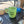 Load image into Gallery viewer, A light green ceramic coffee mug with 'Color Coffee' printed in black script, sitting on a black drip tray inside what appears to be a vehicle or small kitchen setting.
