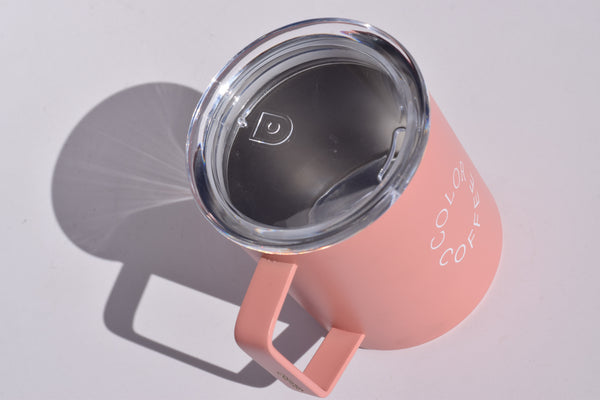 Pink mug with a clear lid on a light gray background