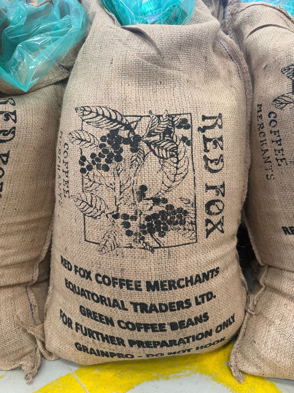 Burlap coffee bags with branding and text on a light background