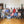 Load image into Gallery viewer, Group of people posing for a photo in a room with wooden floor and white walls.
