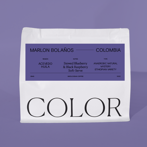 A white bag of Marlon Bolaños Colombia coffee with a prominent purple label, set against a solid lavender background.