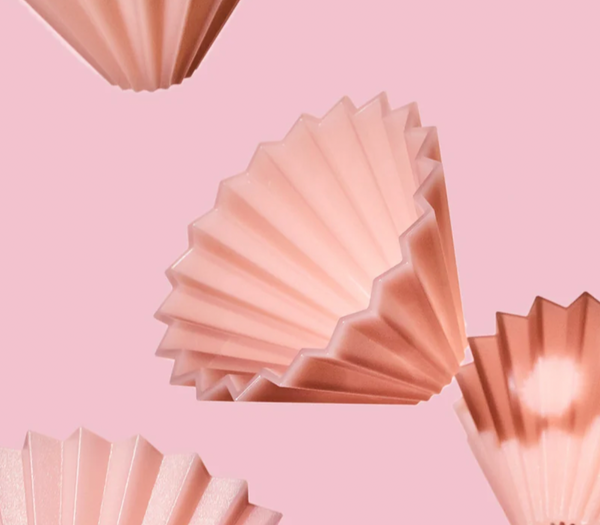 Pink pleated paper cupcake liners floating against a solid pink background.