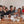 Load image into Gallery viewer, Group of people participating in a coffee tasting session at a wooden table.
