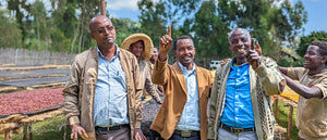 a group of male coffee producers showing one finger for number one