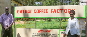 a man and a women from kenya in front of the sign of the coffee farm