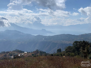 Scenic view of mountains and valleys with clouds in the sky, featuring the brand 'sweet marias'.