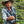 Load image into Gallery viewer, latin america coffee farmer holding a coffee cherry with coffee bean plants in the background
